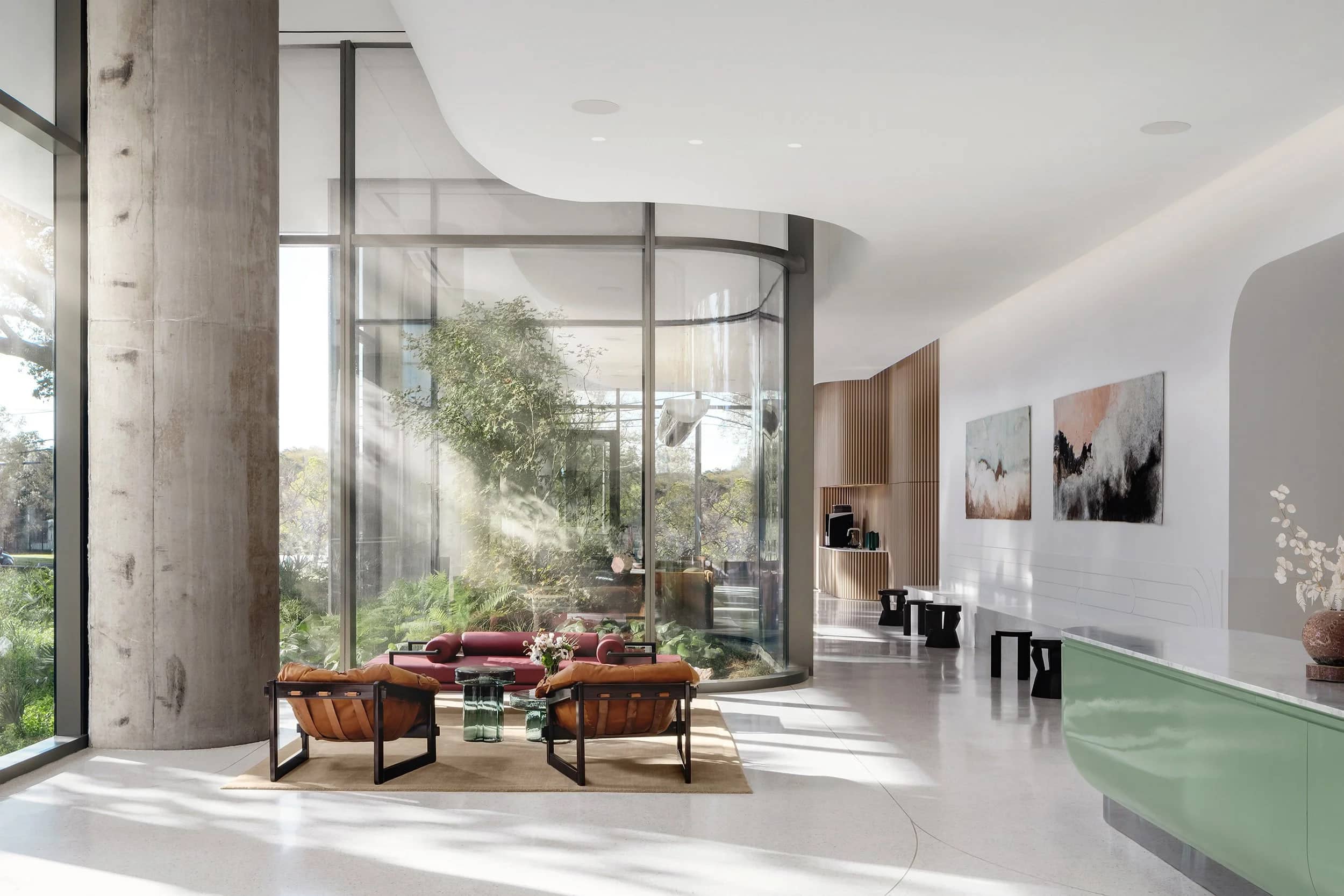 A tower lobby with a long stone reception desk under a coffered ceiling, warm light on a polished floor.